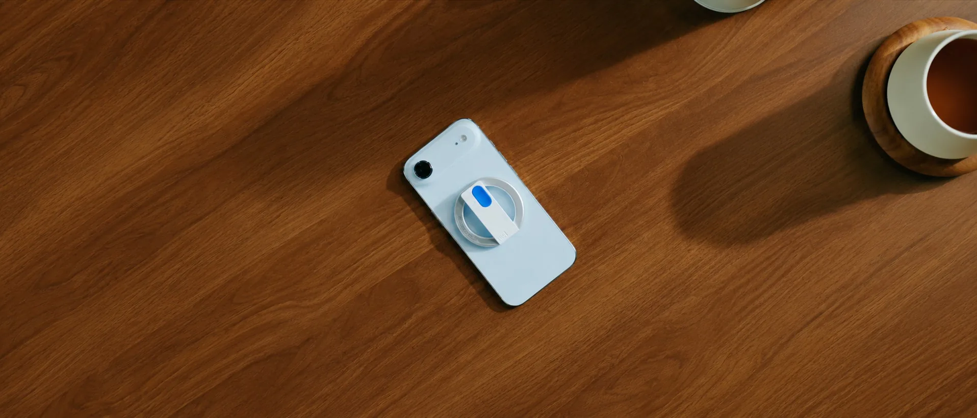 Relay MagSafe Remote attached to a phone on a wooden table